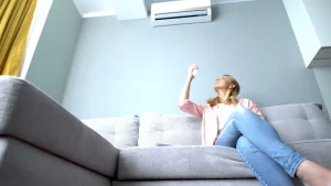 jeune femme se relaxant dans son salon climatisé